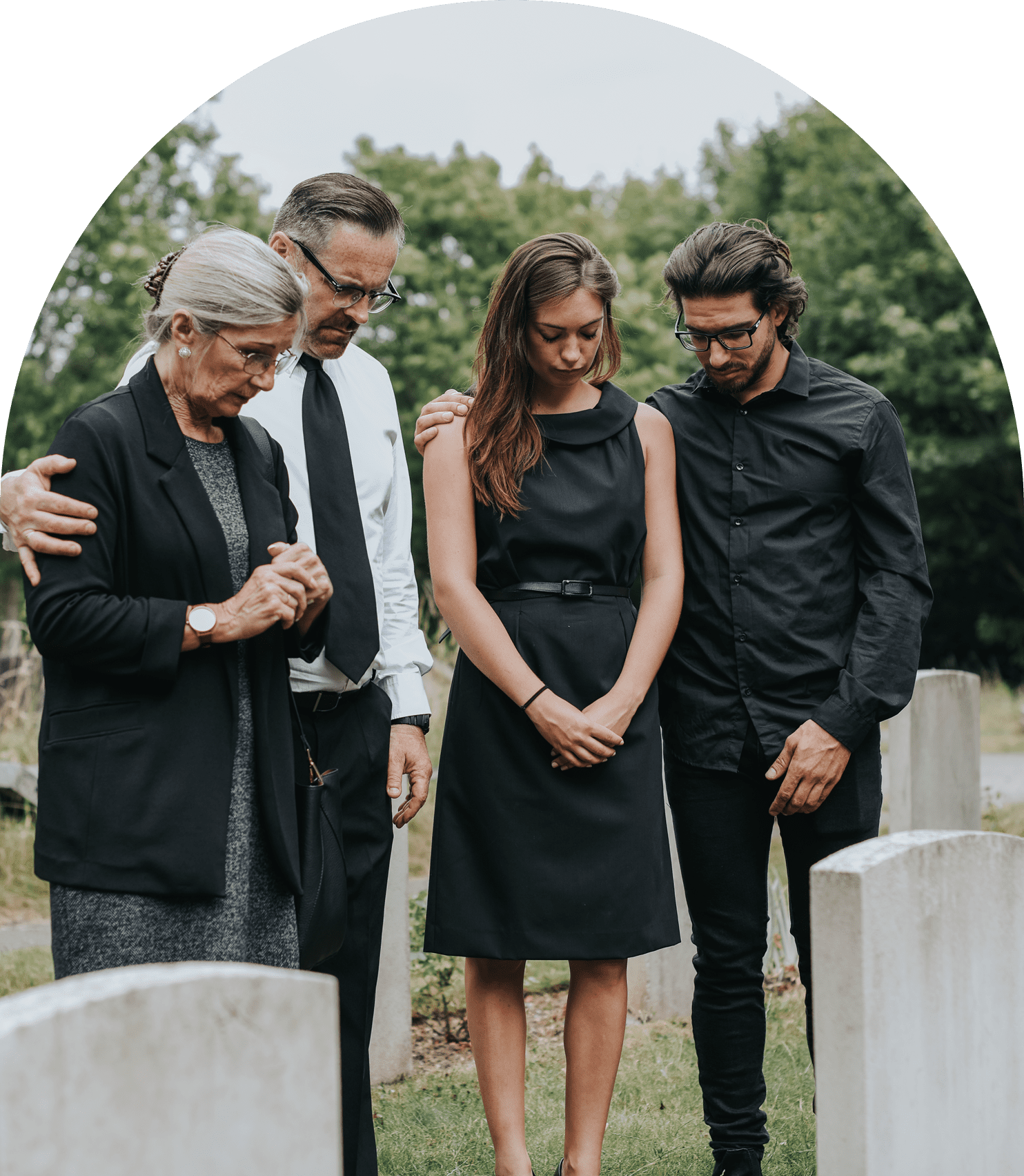 Four people grieving at a cemetery.